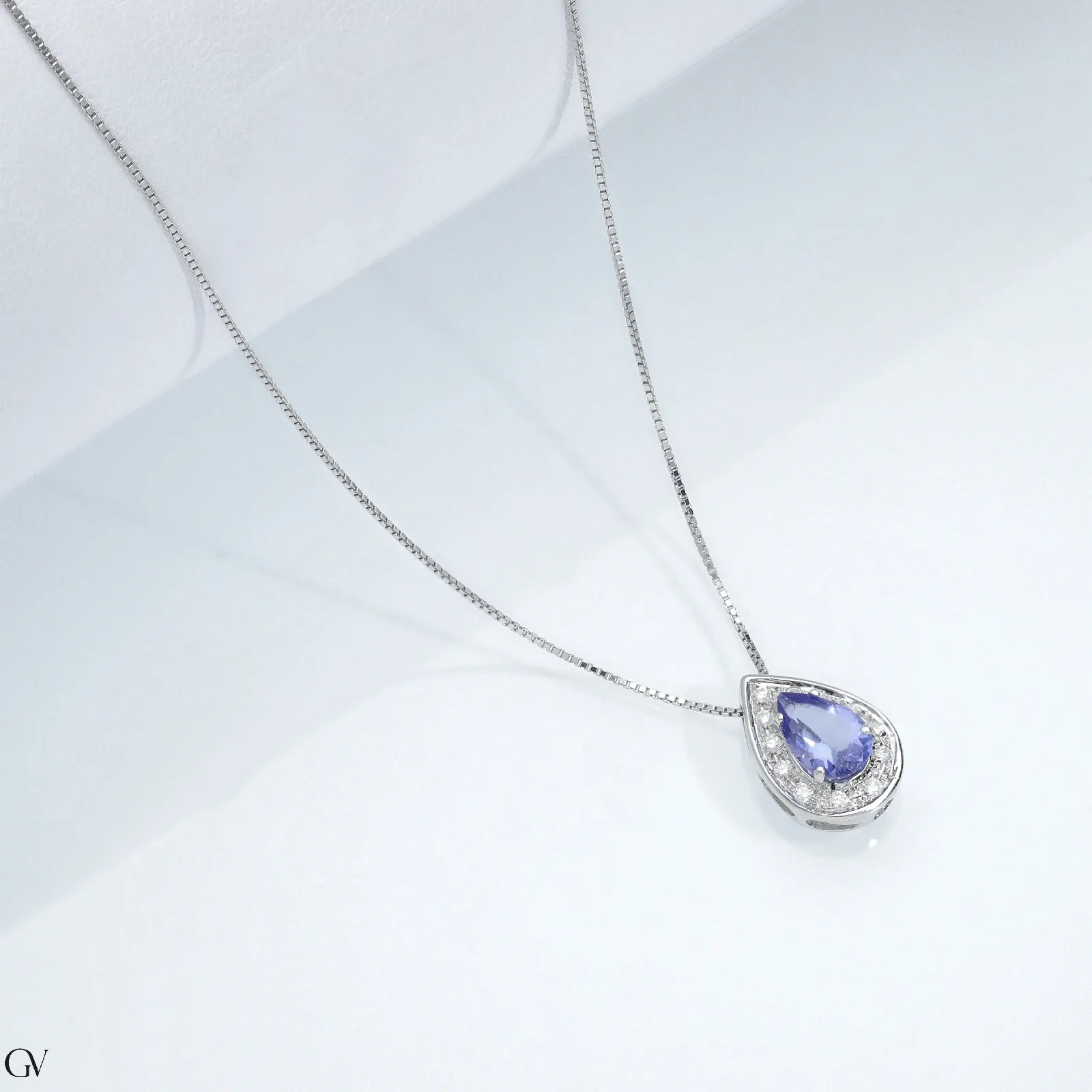 Collana con ciondolo in oro bianco 18k, tanzanite a goccia e diamanti a contorno. Misura circa 1.25x0.85 cm